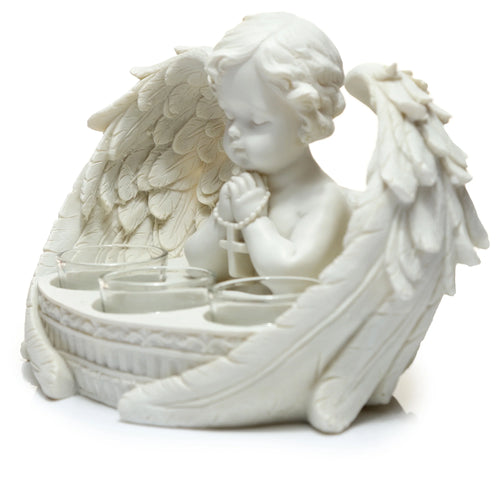 White cherub tea light holder. Angled view showing the praying winged cherub with a rosary, and three glass tea light cups.