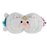 Front view of a white plush unicorn eye mask with a golden horn, black eyes, and pink snout, resting on a white plush travel pillow featuring colourful faux fur accents.