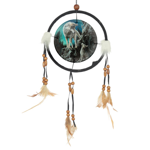 Front view of a dreamcatcher featuring a central circular wolf design, depicting an adult and pup on a teal-toned rocky background. The black outer ring is decorated with white faux fur tufts and three hanging black cords, each with light brown wooden beads and natural-coloured feathers.