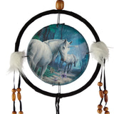 Front view of a unicorn dreamcatcher, featuring a central disc with an illustration of a white adult unicorn and foal in a mystical blue-green forest, surrounded by purple butterflies. It has a black velvet-wrapped hoop, white fluffy embellishments, hanging black cords, and natural wooden beads, with a small wooden bead at the top for hanging.