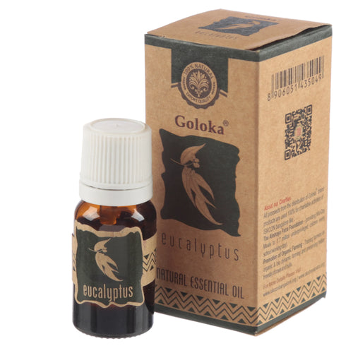Angled view of a Goloka Eucalyptus Natural Essential Oil amber glass bottle with a white ridged screw cap, next to its natural brown cardboard box. Both feature dark green eucalyptus leaf designs and 'eucalyptus' text, with the box also showing 'Natural Essential Oil' and a '100% Natural' logo.