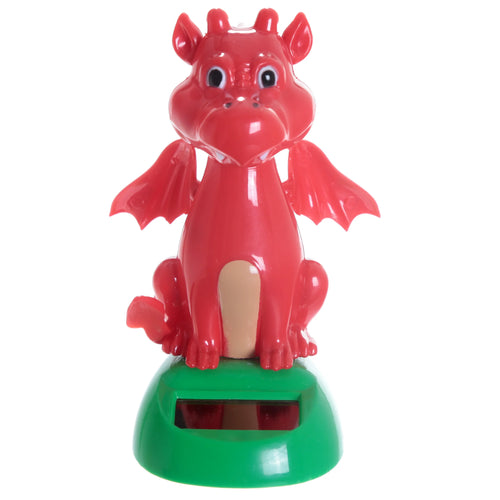 Front view of a bright red Welsh Dragon Solar Pal with small wings, black eyes, and a light brown belly, sitting on a green base featuring a black solar panel.