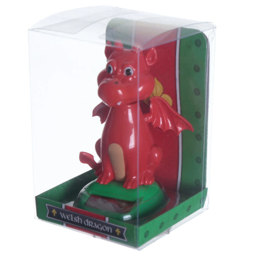 Front view of a red Welsh Dragon Solar Pal figure, featuring small wings and a light-coloured belly. The product is displayed in clear plastic packaging with a green base and red backing, showing the 'Welsh dragon' title and a yellow decorative symbol.