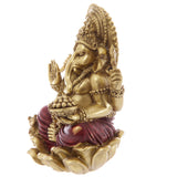 Angled view of a golden and red Ganesh statue, seated on a lotus base, holding a bowl of sweets, with one hand raised and a small mouse figure visible.