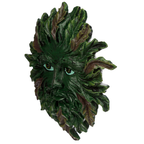 Angled view of a Greenman wall plaque, depicting a face sculpted from green and brown foliage with striking light blue eyes, on a white background.