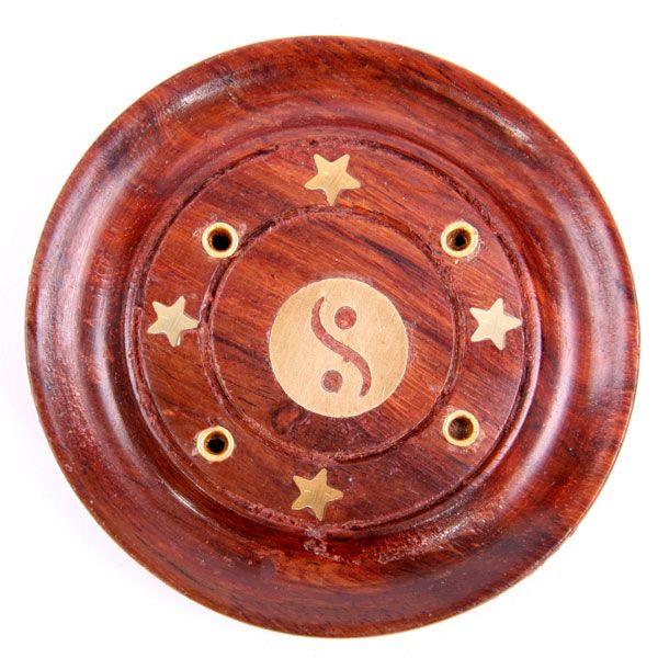 Overhead view of a round Sheesham wood incense holder and ashcatcher, featuring a central brass-coloured Yin Yang inlay, four brass-coloured stars, and four small holes for incense sticks.