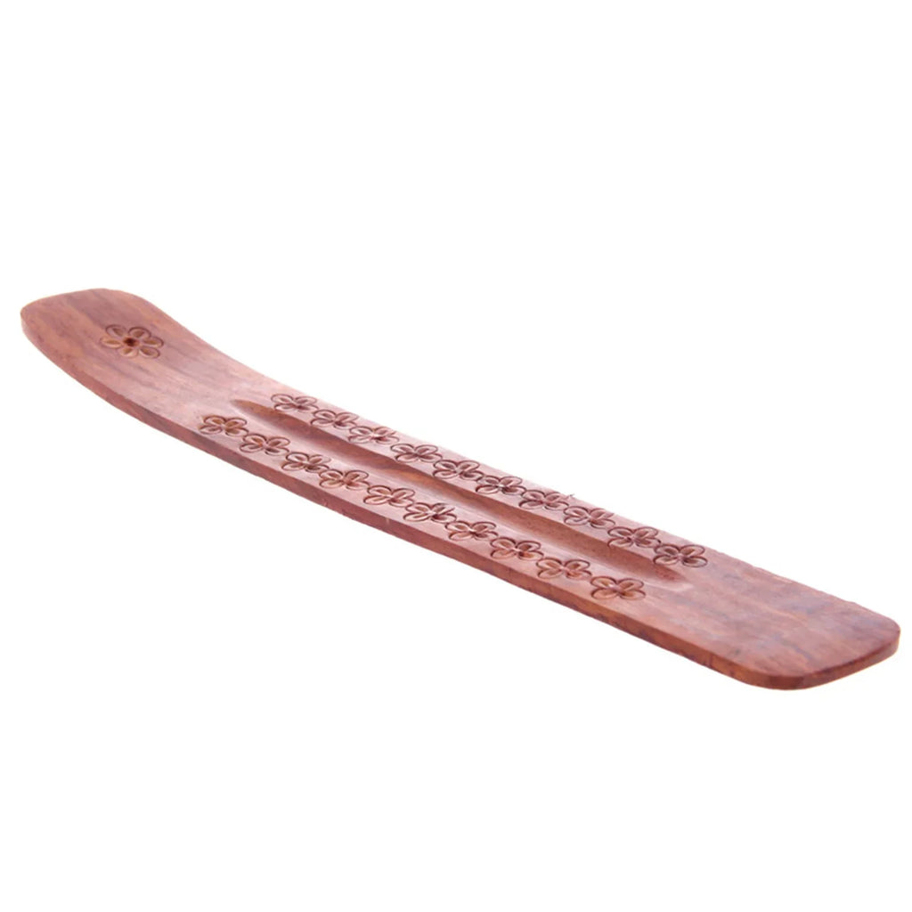 Angled view of a reddish-brown Sheesham wood ashcatcher incense stick burner, showing intricate flower engravings along its central ash groove.