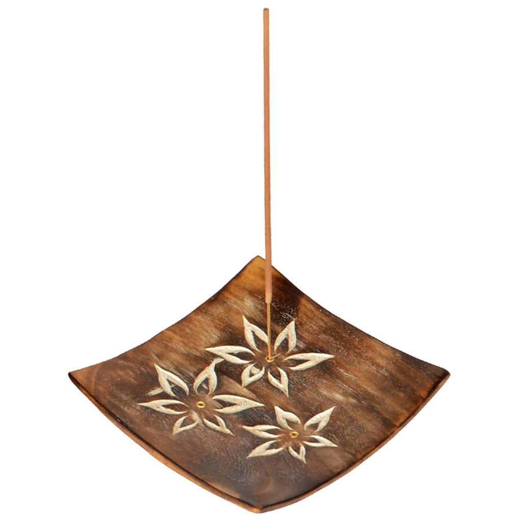 Angled view of a square mango wood incense stick holder and ashcatcher, featuring light carved floral designs and an incense stick standing upright.