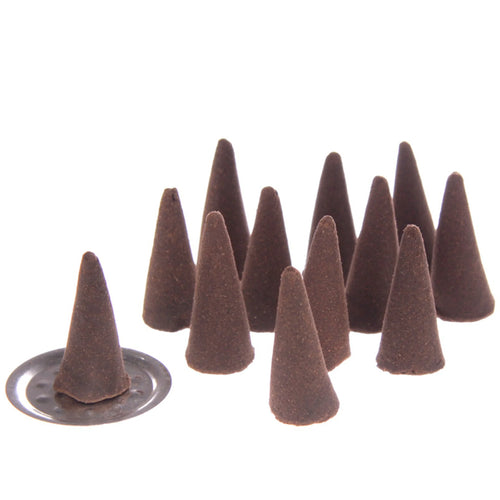 Angled view of several dark brown conical incense cones, one resting on a small, round silver incense holder.