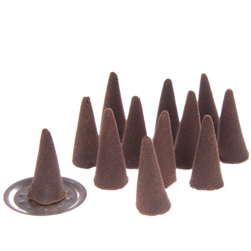 Angled view of multiple dark brown incense cones, one placed on a small circular silver-coloured metal holder, arranged on a white background.