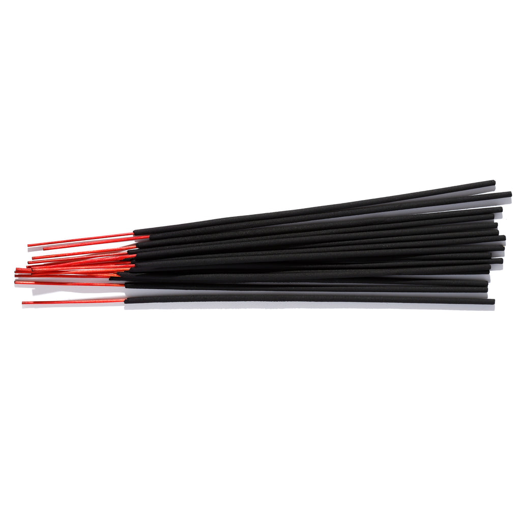 A bundle of black incense sticks with red ends, arranged horizontally on a white background.