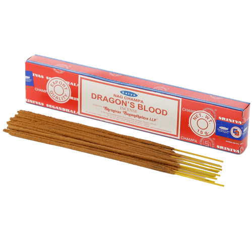 Angled view of a red and white box of Dragon's Blood Nag Champa incense sticks, with a pile of brown incense sticks featuring yellow bamboo cores laid diagonally in front.