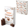Angled view of a white retail display box containing six smaller individual packs of backflow cinnamon incense cones. In the foreground, a separate individual pack is shown alongside four loose dark brown conical backflow incense cones. One cone lies on its side, showing its base hole, while three others stand upright. The packaging features 'Backflow Cinnamon Incense Cones' text and illustrations of cinnamon sticks.