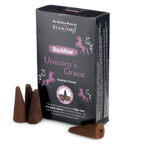 Angled view of a dark box of Stamford 'Unicorn's Grace' backflow incense cones, featuring purple unicorn illustrations and text indicating an aloe vera and green leaves scent. Several loose brown backflow incense cones are visible, one lying on its side to show its base hole.