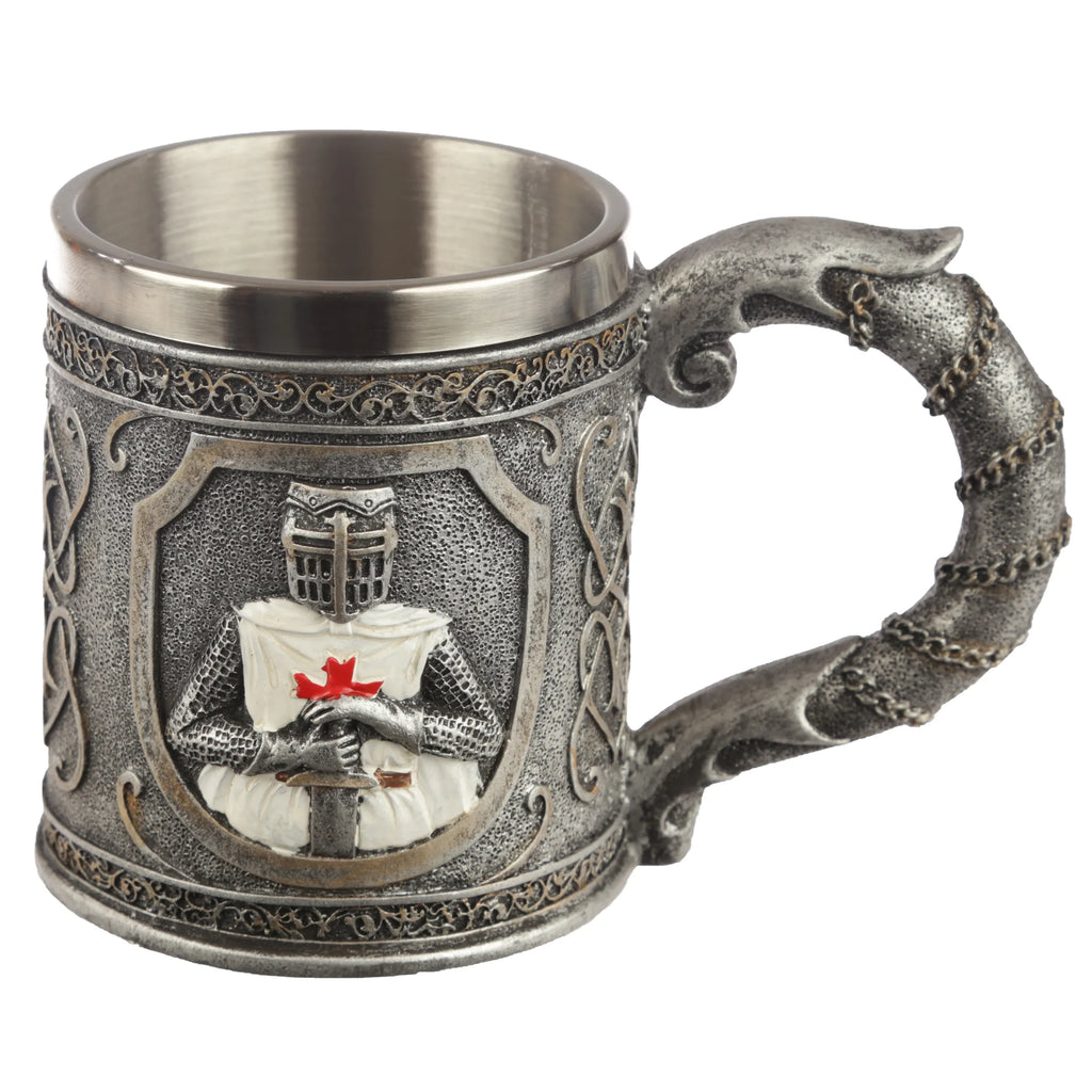 Front view of a decorative crusader knight tankard, in metallic-effect grey, featuring a prominently embossed knight figure with a red cross emblem, intricate Celtic knotwork, and a textured handle adorned with a chain design.