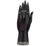 Front view of a small black hand figurine, featuring white-tipped fingernails and intricate white patterns on the fingers and wrist.