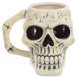 Front view of an ancient skull head ceramic shaped mug, featuring a textured cream and grey finish, dark black eye sockets, and a bone-shaped handle.