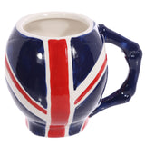 Angled view of a ceramic skull-shaped mug with a Union Jack design in blue, red, and white, featuring a bone-shaped handle, with the top opening visible.