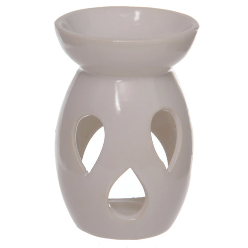 Angled view of a simple white ceramic oil and wax burner, featuring tear-drop cut-outs on its body and a top dish.
