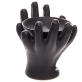 Angled view of a dark grey ceramic oil burner, designed with open cupped hands supporting a round dish, and a cut-out base.