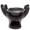 Dark grey ceramic open hands oil burner, depicting cupped hands holding a top bowl, with a visible arched opening for a candle at the base.