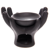 Dark grey ceramic open hands oil burner, depicting cupped hands holding a top bowl, with a visible arched opening for a candle at the base.