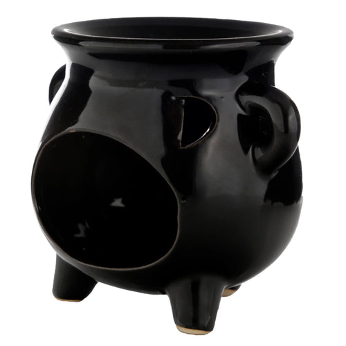 Large black glossy ceramic cauldron oil burner shown from an angled view, highlighting its three legs, side handles, and the prominent circular opening for a tealight.
