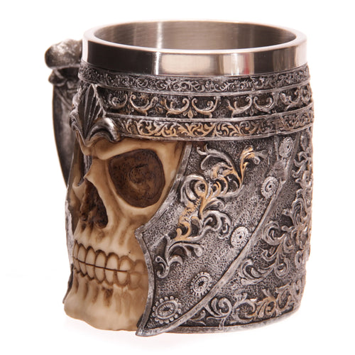 Angled view of a decorative skull warrior tankard, showing a bone-coloured skull profile wearing ornate silver armour with gold accents, and a metallic inner rim.