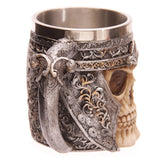 Angled view of a decorative skull warrior tankard, showcasing an intricate silver-coloured handle and a detailed skull design with golden accents, with a visible stainless steel interior.