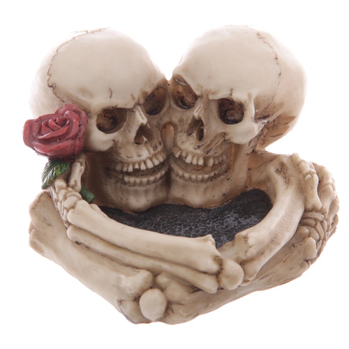 Bone-coloured Skull Lovers ashtray depicting two embracing skulls, one featuring a red rose, with a dark textured basin.