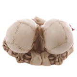 Top-down view of a bone-coloured Skull Lovers ashtray, showing two entwined skulls with detailed cranium sutures.