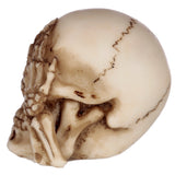 Right side view of a small, cream-coloured 'Hear No Evil' skull figurine with brown distressed details, showing its skeletal hands covering its ears.