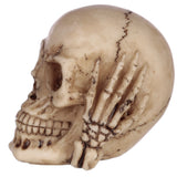 Close-up left profile view of a small, cream-coloured 'Hear No Evil' skull ornament, featuring an aged finish, intricate bone details, and a skeletal hand covering its ear.
