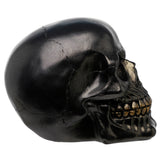 Metallic black skull decoration in side profile, with a sparkling finish and gold-coloured teeth.