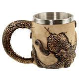 Angled side view of a decorative tankard, featuring bronze octopus tentacles forming the handle and wrapping around a cream-coloured, skull-like body with a cracked appearance, and a stainless steel inner lining.