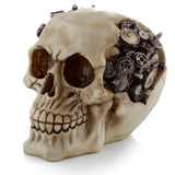 Angled view of an aged bone-coloured steampunk skull ornament, featuring intricate tarnished metallic cogs and gears embedded within.