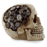 Steampunk style skull ornament, an angled view revealing numerous metallic cogs and gears intricately embedded in the top and side of the light-coloured, bone-effect skull figurine.