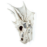 Angled view of a cream dragon skull decoration, featuring dark eye sockets and metallic silver plates and studs.