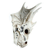 Angled view of a bone-coloured dragon skull decoration with metallic detailing on its face and jaw, featuring prominent wing-like structures.