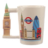 Angled view of a cream ceramic mug with a sculpted Big Ben handle. The mug's body is decorated with illustrations of London icons, including Big Ben, the London Underground roundel, The Gherkin, Tower Bridge, and a red double-decker bus.