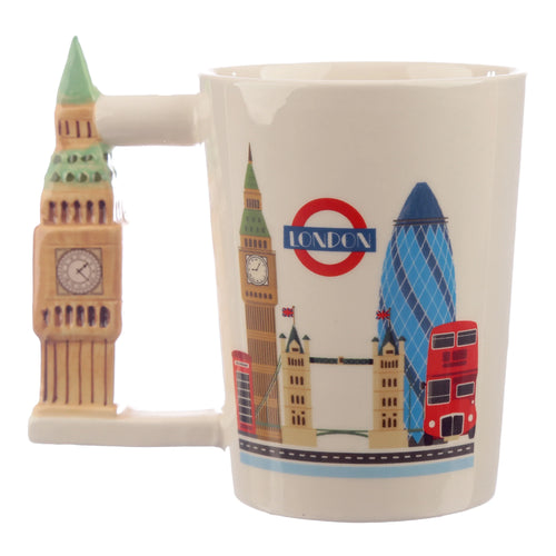 Angled view of a cream ceramic mug with a sculpted Big Ben handle. The mug's body is decorated with illustrations of London icons, including Big Ben, the London Underground roundel, The Gherkin, Tower Bridge, and a red double-decker bus.
