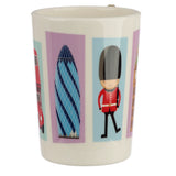 Cream ceramic mug with a graphic London-themed pattern. Features illustrated panels depicting a red double-decker bus, The Gherkin skyscraper, and a Queen's Guard in uniform. A small, shaped handle detail is visible on the rim.