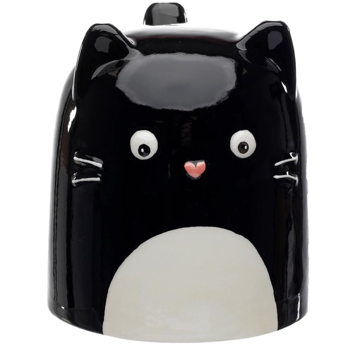 Front view of a glossy black ceramic cat upside down mug, featuring white eyes, a pink nose, white whiskers, and a large white patch on its lower front.