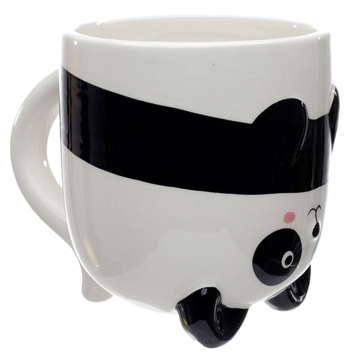 Angled view of a white and black ceramic panda shaped mug, showing the panda's face with a pink cheek and black feet on its base, and a white handle.