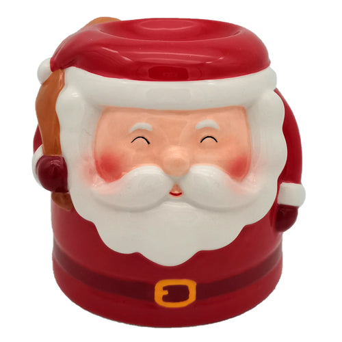 Front view of a red and white ceramic Santa shaped Christmas oil burner, depicting Santa's smiling face with rosy cheeks, white beard, red hat, golden buckle, and a brown sack.