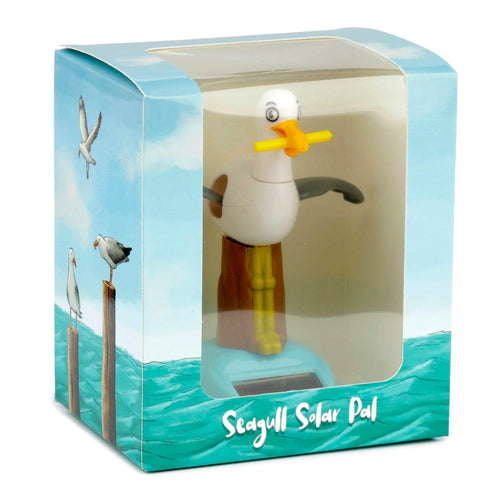 Front view of a Collectable Solar Powered Pal Seagull in its retail display box. The white seagull figure with yellow beak and grey wings is visible through a clear window, mounted on a blue base with a solar panel. The box features coastal illustrations and Seagull Solar Pal text.