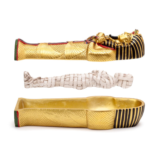 Side view of a gold Egyptian Tutankhamen sarcophagus trinket box, with its ornate lid, white mummy figure, and hollow base displayed separately.
