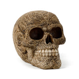 Angled view of a beige Damask Skull Ornament, prominently displaying its intricate swirling patterns and floral motifs, along with visible eye sockets, nasal cavity, and individual teeth, on a white background.