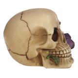 Left side view of a beige Gothic skull decoration featuring a cracked texture, purple roses, and a green leaf.