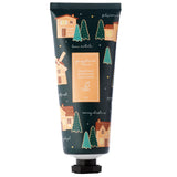 A front view of a dark teal 75ml hand cream tube, featuring a festive gingerbread lane pattern with gingerbread houses, green fir trees, white snowflakes, and yellow stars. The central label reads 'Gingerbread Moisturising Hand Cream'.